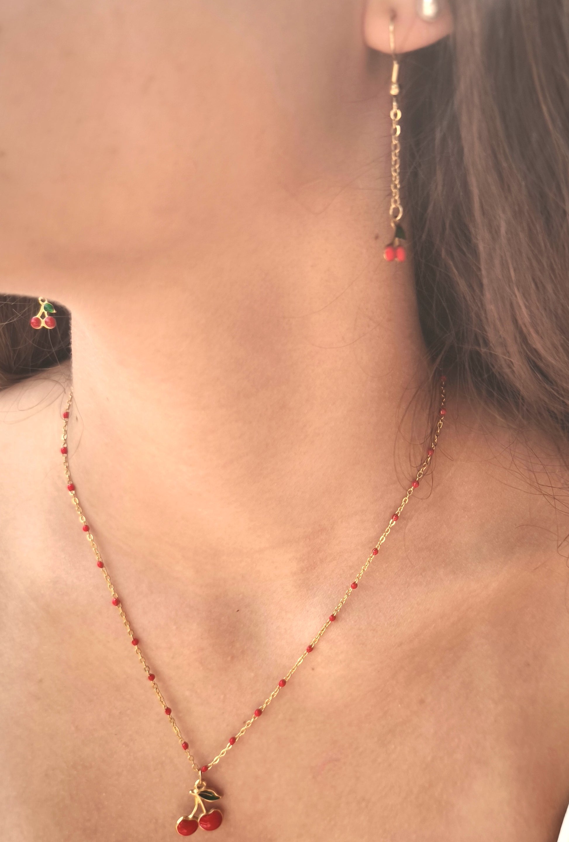 bracelet en acier inoxydable et perle rouge. bracelet de main avec une pampille cerise très moderne pour l'été
