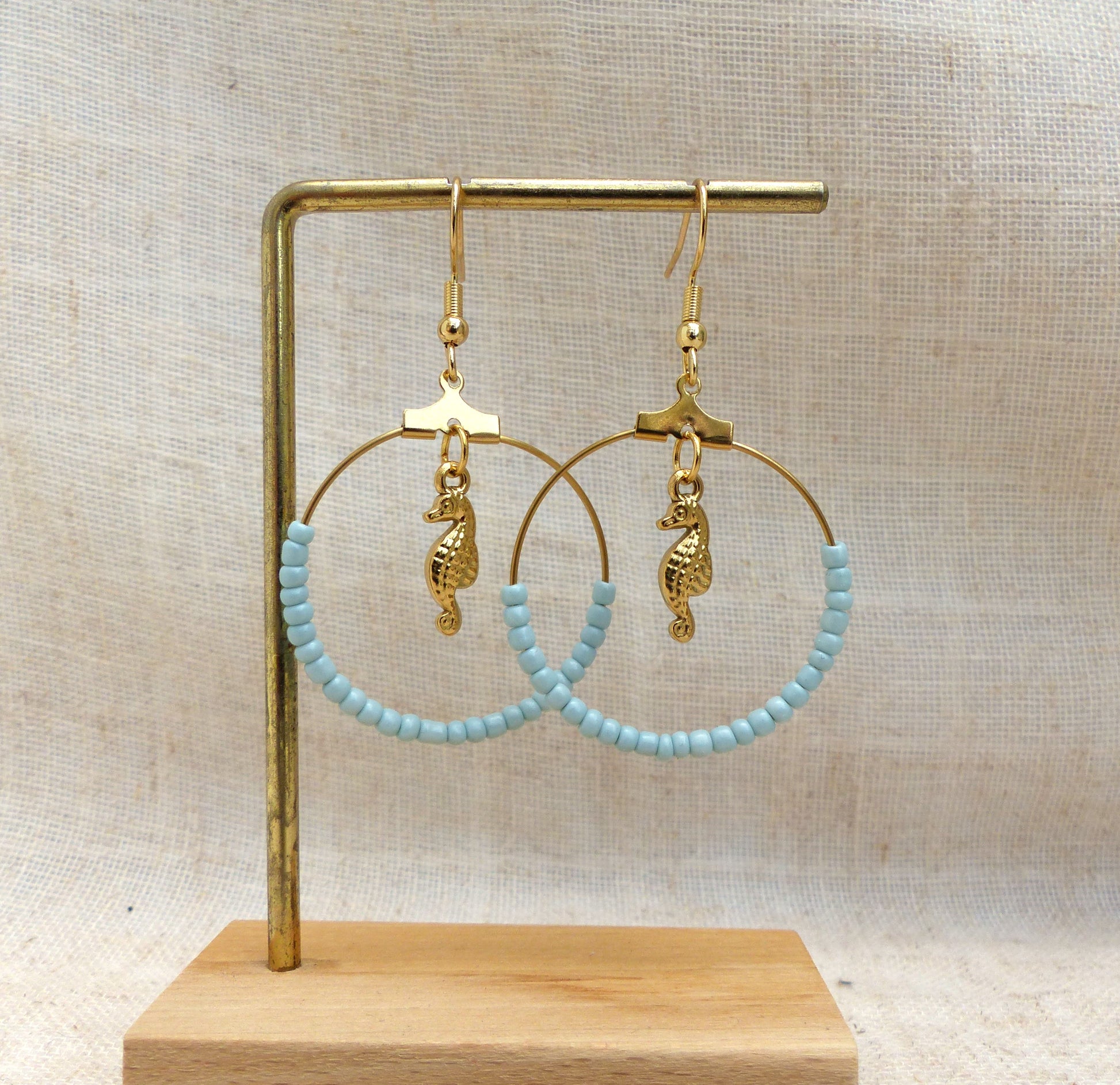 boucles d'oreilles faites à la main en France en acier inoxydable pendentif hippocampe et perles bleues claires