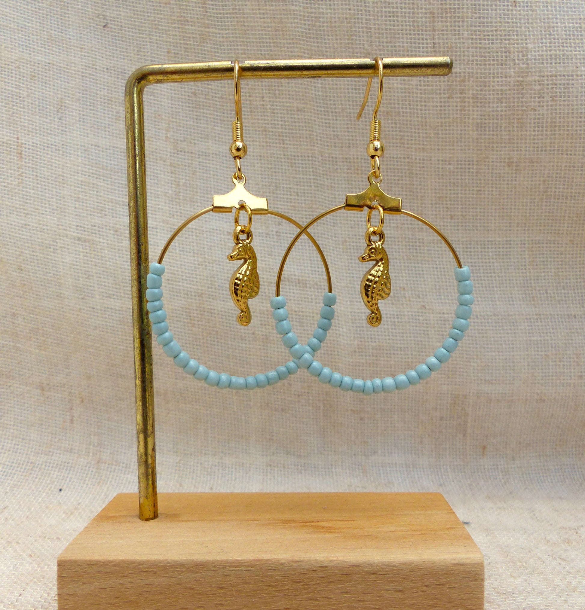 boucles d'oreilles faites à la main en France en acier inoxydable pendentif hippocampe et perles bleues claires