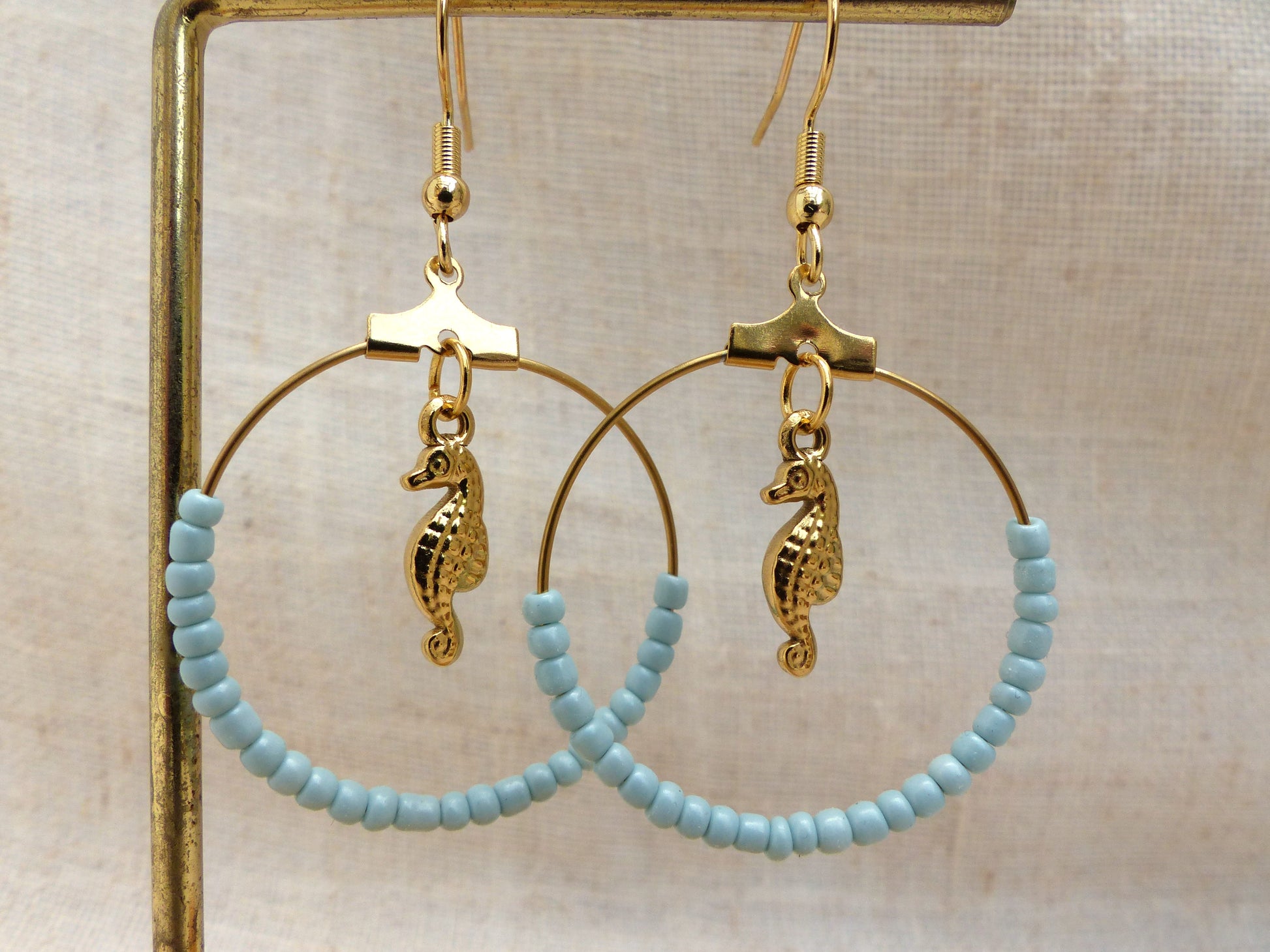 boucles d'oreilles faites à la main en France en acier inoxydable pendentif hippocampe et perles bleues claires